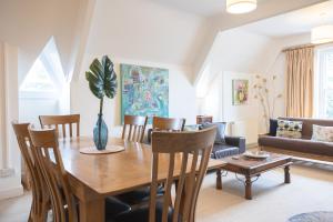 a living room with a wooden table and chairs at Spacious 3BR Victorian Cheltenham loft flat in Cotswolds Sleeps 8 - FREE Parking in Cheltenham