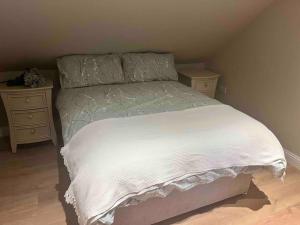 a bedroom with a white bed with two night stands at Mid Antrim Modern Apartment in New Ferry