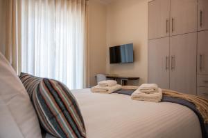 a bedroom with two beds with towels on them at Konstantina's Luxury Apartment in Nafplio