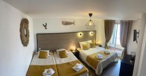 Pokój hotelowy z 2 łóżkami i lustrem w obiekcie Hotel Alcyon w mieście Valras-Plage