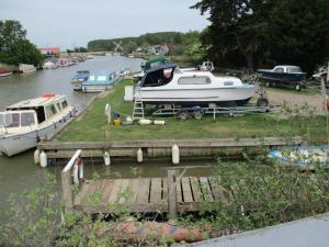 a boat is docked at a dock on a river at Bridge Stores in Fritton