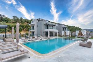 a villa with a swimming pool and lounge chairs at Luxurious villa Micha Mare - 14 Bedrooms in Roumelí