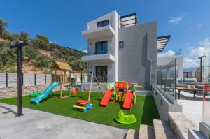 a house with a playground in front of it at Luxurious villa Micha Mare - 14 Bedrooms in Roumelí