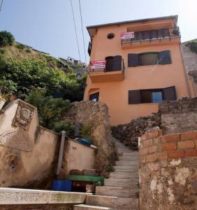 un edificio su una collina con scale di fronte di Casa Arancio Chianalea Scilla a Scilla