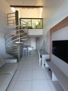 a living room with a spiral staircase and a table at Laguna Beach Flat in Porto De Galinhas