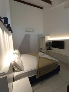 a small bed in a room with a light at Laguna Beach Flat in Porto De Galinhas