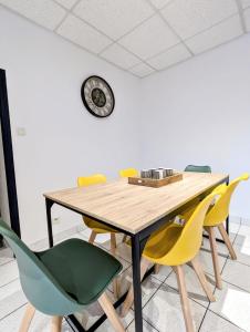 a dining room table with yellow and green chairs at maison de vacances 5 personnes in LʼOie +7 photos