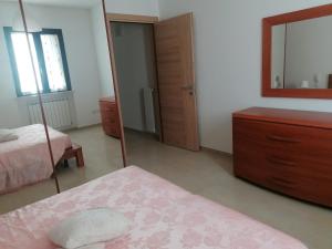 加拉蒂納的住宿－Albachiara，一间卧室配有两张床、一个梳妆台和镜子