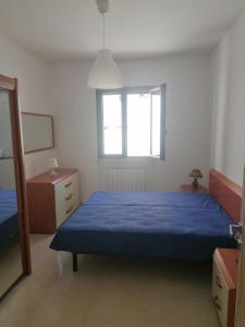 a bedroom with a blue bed and a window at Albachiara in Galatina