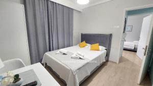 a bedroom with a bed with yellow pillows on it at Vasileiadou Coastal Rooms in Flogita