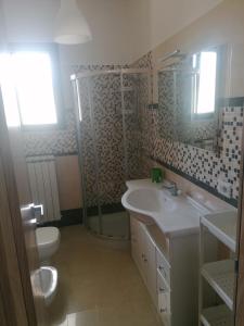 a bathroom with a sink and a shower and a toilet at Albachiara in Galatina