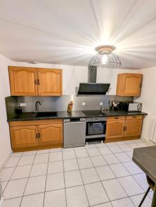 a kitchen with wooden cabinets and a sink at maison de vacances 5 personnes in LʼOie