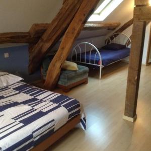 1 Schlafzimmer mit 2 Betten in einem Zimmer mit Holzbalken in der Unterkunft Gite de la source in Saint-Rémy