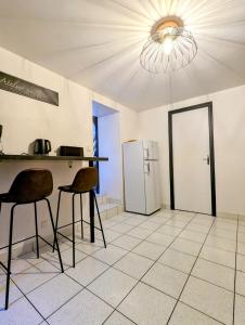 eine Küche mit einem Tisch, 2 Stühlen und einem Kühlschrank in der Unterkunft maison de vacances 5 personnes in LʼOie