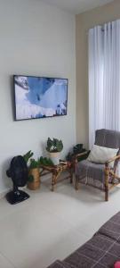 卡馬薩里的住宿－Casa Aconchegante com Piscina Barra do Jacuípe，客厅配有椅子和盆栽植物
