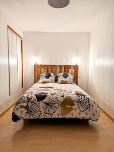 a bedroom with a bed with a wooden headboard at maison de vacances 5 personnes in LʼOie