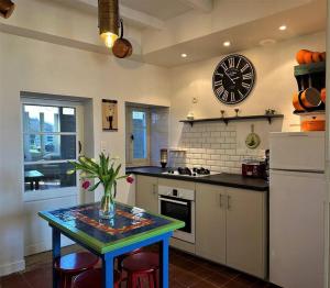 a kitchen with a table and a clock on the wall at Happiness Verteuil sur Charente in Verteuil-sur-Charente