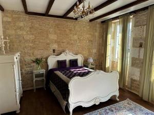 a bedroom with a white bed and a brick wall at Happiness Verteuil sur Charente in Verteuil-sur-Charente