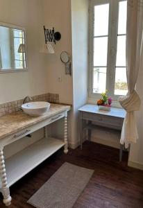 a bathroom with a sink and two windows at Happiness Verteuil sur Charente in Verteuil-sur-Charente