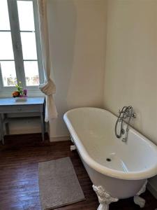 a white bath tub in a bathroom with a window at Happiness Verteuil sur Charente in Verteuil-sur-Charente