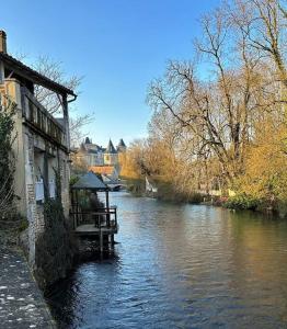 a person sitting on a bench on a boat in a river at Happiness Verteuil sur Charente in Verteuil-sur-Charente