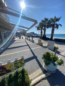 a walkway with benches and palm trees on the beach at Kuşadası kadınlar denizi (BİDRi İNŞAAT) in Kuşadası