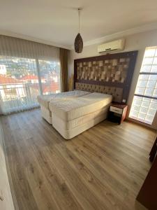 a large bedroom with a large bed and wooden floors at Kuşadası kadınlar denizi (BİDRi İNŞAAT) in Kuşadası