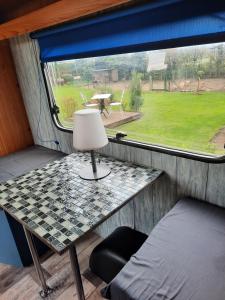 een tafel in een tiny house met een raam bij la Carabol Der in Voillecomte