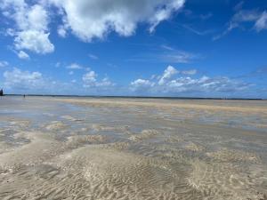 a sandy beach with a blue sky and clouds at Casa verde no Pontal de Maracaipe in Porto De Galinhas