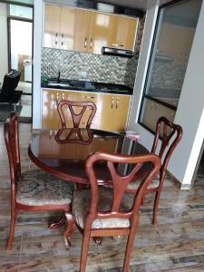 mesa de comedor, 2 sillas y cocina en Casa Bertha Hotel y Servicios SAS, en Nobsa
