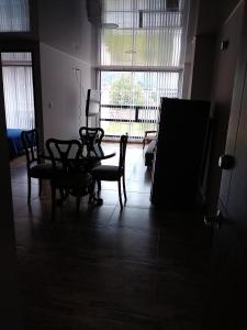 a dark room with a table and chairs and a window at Casa Bertha Hotel y Servicios SAS in Nobsa