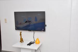 una TV a schermo piatto appesa a un muro bianco di Tranquillité Cotonou a Cotonou