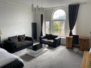 a living room with two couches and a window at Premier 2 bed Flat C in Broxburn