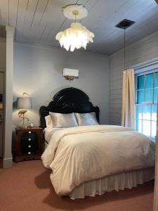 Carriage House Bed & Breakfast في وينونا: غرفة نوم بسرير كبير وثريا