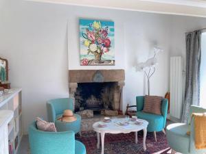 uma sala de estar com cadeiras, uma mesa e uma lareira em KER MAJA : Charmante Maison 1930 * Jardin * 2 vélos * WIFI em Carnac