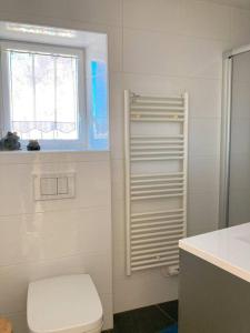 a white bathroom with a toilet and a window at KER MAJA : Charmante Maison 1930 * Jardin * 2 vélos * WIFI in Carnac