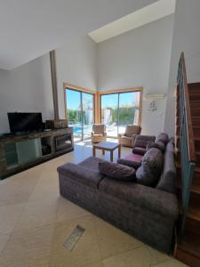 ein Wohnzimmer mit einem großen Sofa und einem TV in der Unterkunft Luxury city Villa Olivia 10 - 15 min to the Beach Oura, private swimming pool in Albufeira