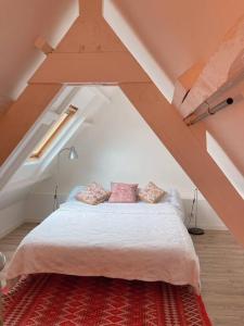 a bedroom with a white bed in an attic at KER MAJA : Charmante Maison 1930 * Jardin * 2 vélos * WIFI in Carnac