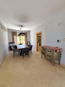 ein Wohnzimmer mit einem Tisch und Stühlen sowie ein Esszimmer in der Unterkunft Luxury city Villa Olivia 10 - 15 min to the Beach Oura, private swimming pool in Albufeira