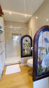 a bathroom with a shower and a toilet and stained glass windows at Boutique B&B Poppy's in Bruges