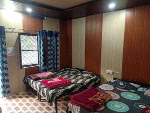 una stanza con due letti e una finestra di SAMAUN Homestay a Kurchhola