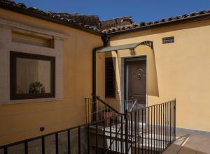 uma casa com uma porta preta e uma varanda em Casa Vacanza da Dina em Modica