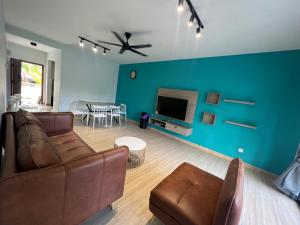 - un salon avec un canapé et un mur bleu dans l'établissement BayView Villas Condo - Premium Unit, à Port Dickson