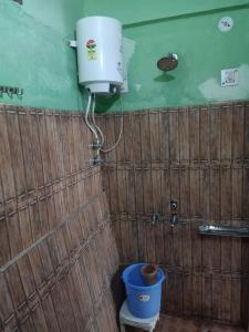 un bagno con una cisterna d'acqua e un secchio blu di SAMAUN Homestay a Kurchhola