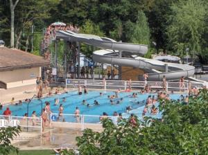 grupa osób w basenie ze zjeżdżalnią w obiekcie Gîte Puydepont w mieście Neuvic