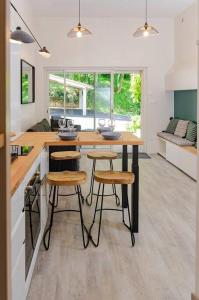 - une cuisine avec une table et des tabourets dans une pièce dans l'établissement Gîte Puydepont, à Neuvic