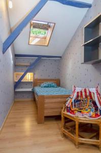 - une chambre mansardée avec un lit et une fenêtre dans l'établissement Gîte Puydepont, à Neuvic