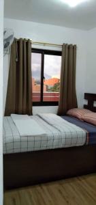 a bed in a room with a window at Leonor's Transient House in Polangui