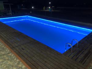 a swimming pool with blue illumination at night at ณ กาญโฮม NaKan Home in Ban Hin Hak