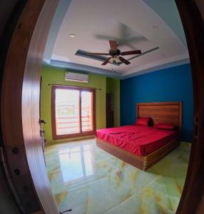 a bedroom with a red bed and a ceiling fan at Tapovan Resort in Rishīkesh
